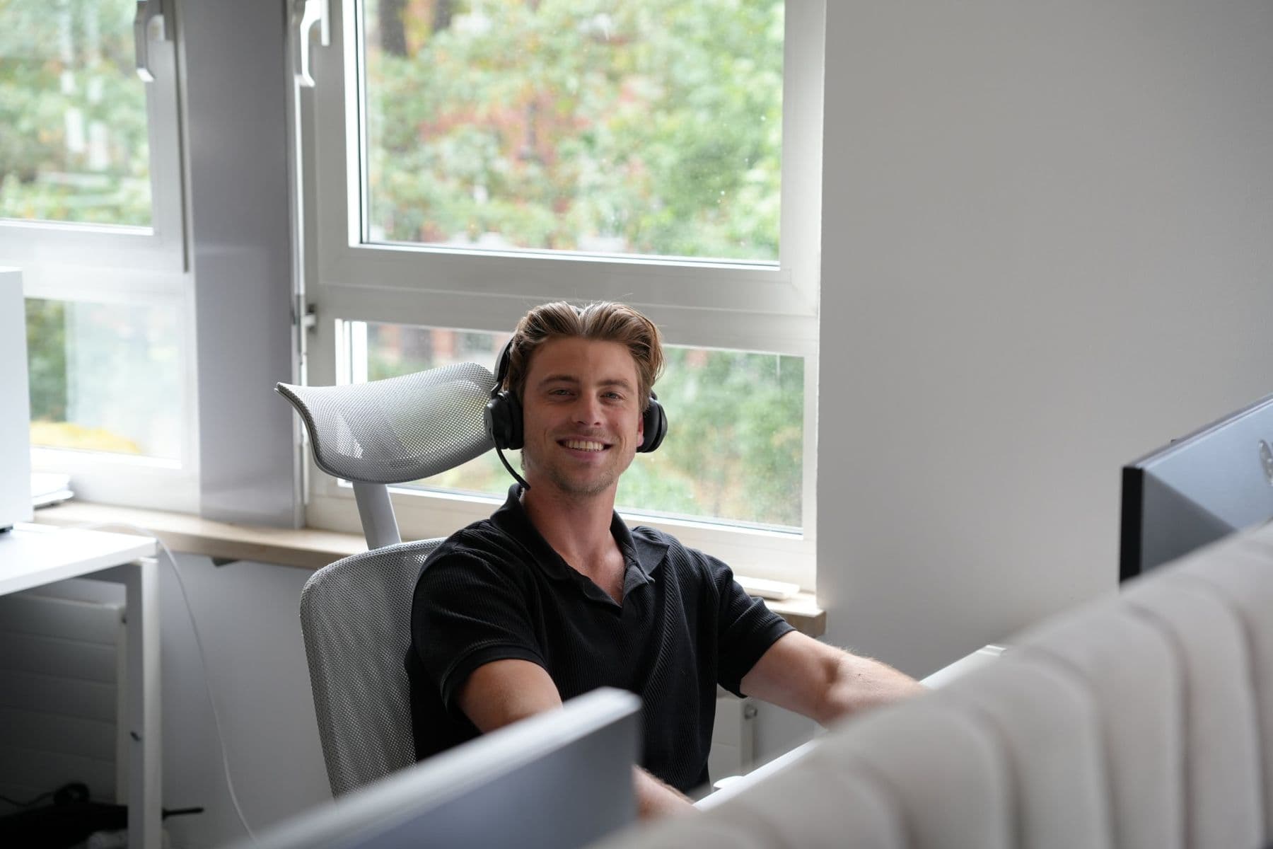 Kollege aus dem Vertrieb am Arbeitsplatz mit Headset