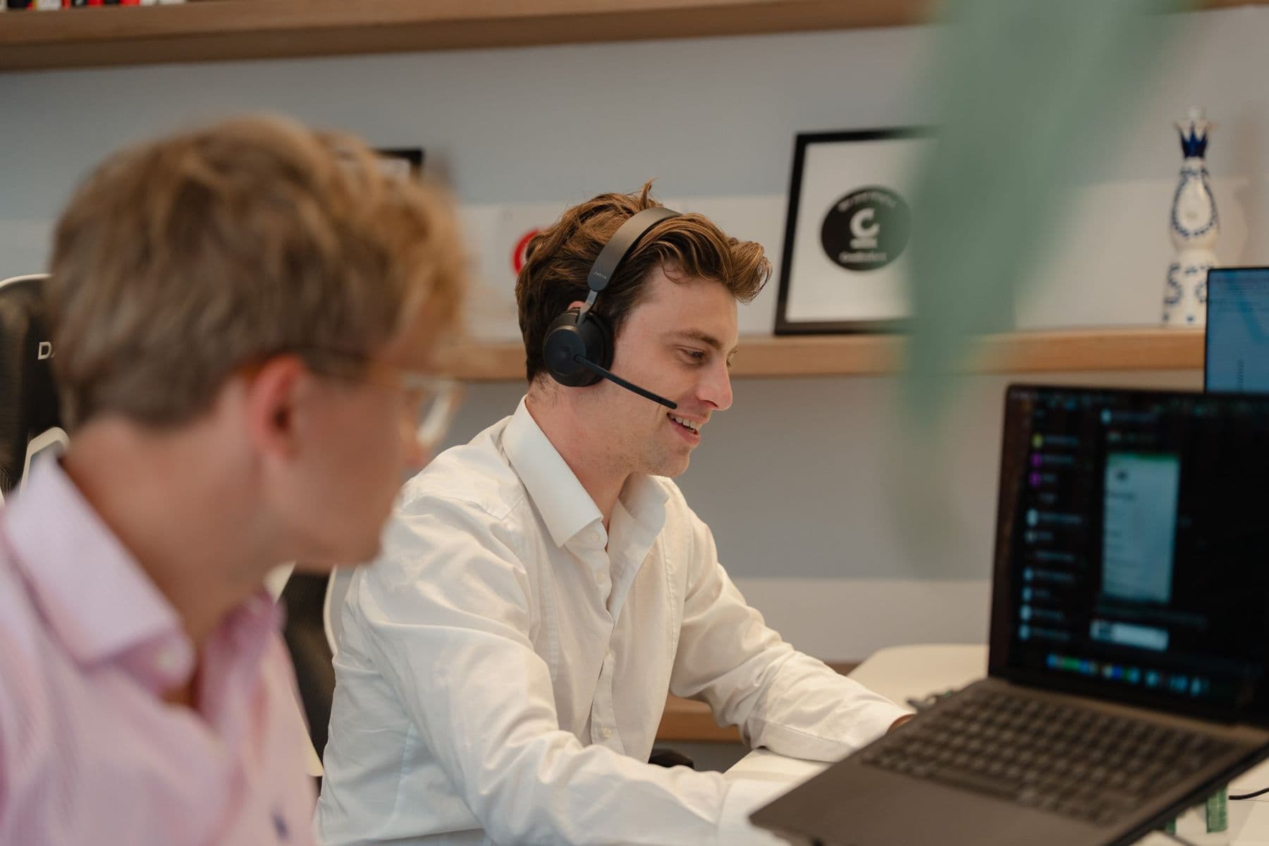 Kollege aus dem Vertrieb im Kundengespräch am Headset